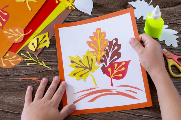 Handen met kleurrijke papieren bladeren op houten tafel