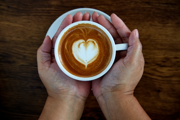 Handen met koffiekopje hart beker