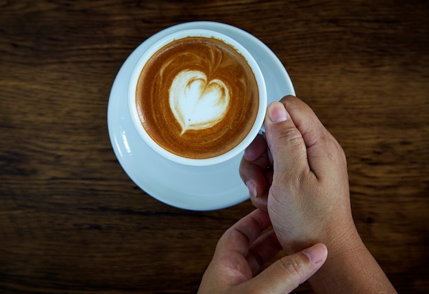 Handen met koffiekopje hart beker