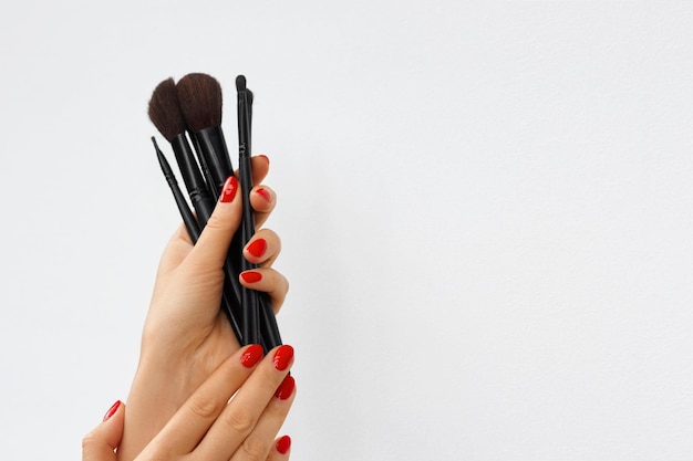 Handen met make-upborstels geïsoleerd op een witte of grijze achtergrond Vogue Style