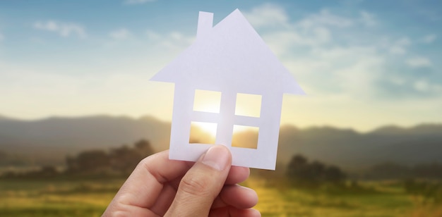 Handen met papieren huis, gezinswoning en bescherming van verzekeringsconcept