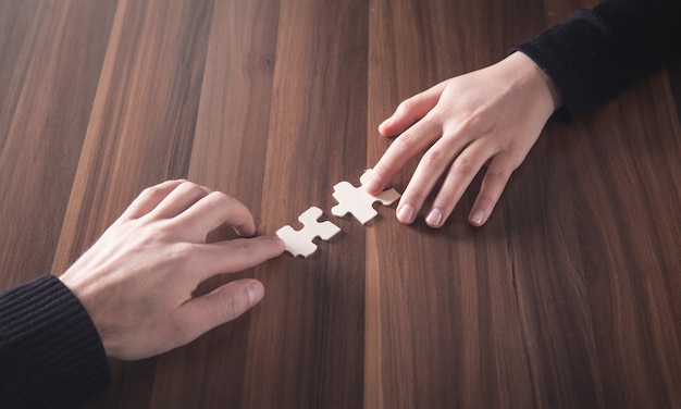 Handen met puzzelstukje. Oplossing, succes, teamwerk