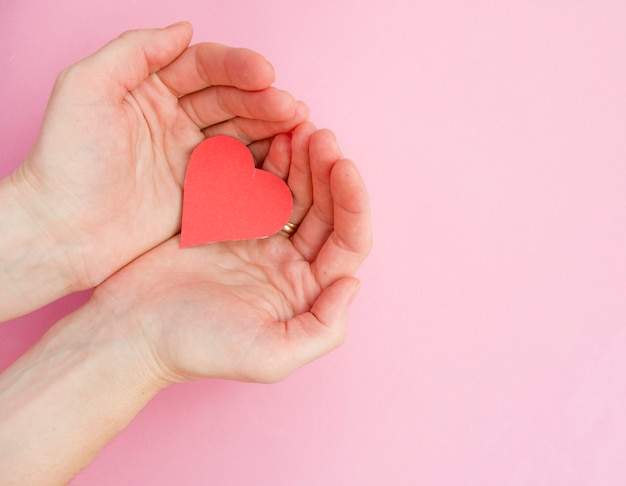 Handen met rood hart, hartgezondheid, donatie, gelukkige vrijwillige liefdadigheid, MVO sociale verantwoordelijkheid, wereldhartdag, wereldgezondheidsdag, werelddag voor geestelijke gezondheid, pleeggezin, welzijn, hoopconcept