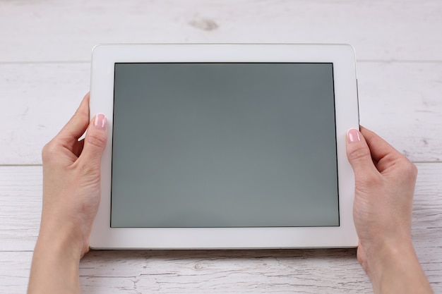 Foto handen met tablet vergelijkbaar met ipades-stijl op houten tafel