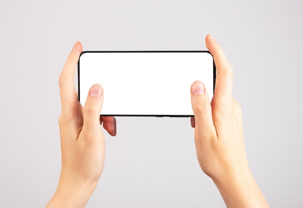 Handen met telefoonmodel in horizontale positie Vrouw die smartphone gebruikt om games te spelen Sjabloon voor mobiel gamen met leeg scherm