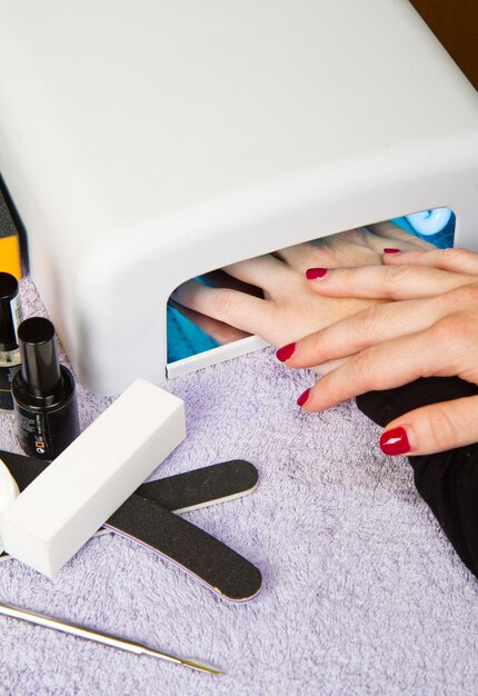 Handen met uv-lamp voor nagels