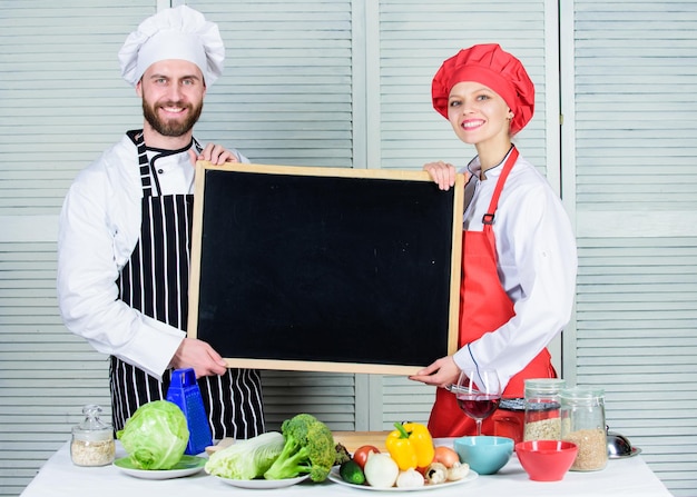 Handen op kookles Paar man en vrouw met leeg schoolbord in kookschool Chef-kok en kokhelper die masterclass onderwijzen Meesterkok en prep-kok die kookles kopieerruimte geven