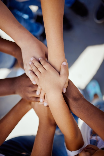 Handen samen en steun kinderen solidariteit en vertrouwen inzet en teammotivatie bovenaanzicht Diversiteit teamwerk en jeugdgroep met ontwikkeling groei en kinderen gemeenschap met verbinding