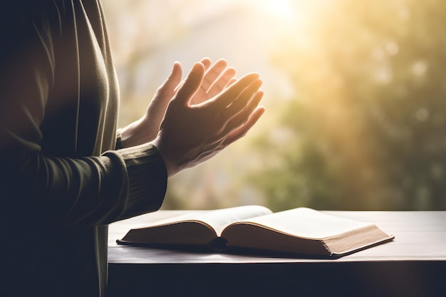 Handen samen in gebed tot God samen met de heilige bijbel boek