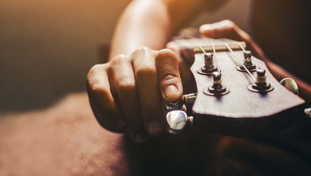 Handen spelen akoestische ukulele-gitaar. Muziekvaardigheden tonen