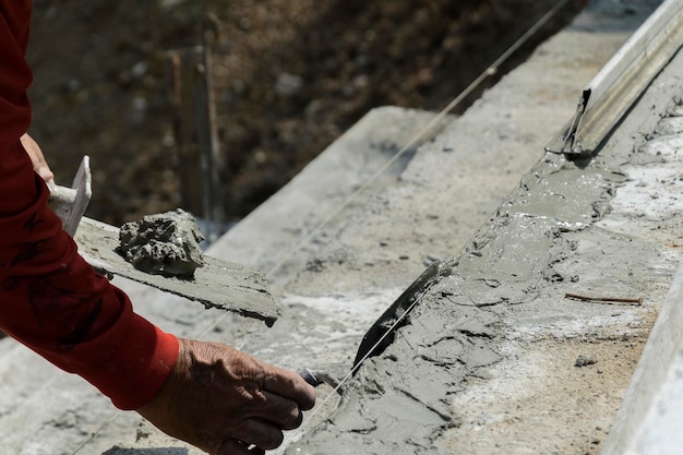 Handen Stukadoor op het werkToepassing van de getextureerde gipstrap cementbetonstructuur in woonhuis gebouw op bouwplaatsIn aanbouw versterken van betonnen trap