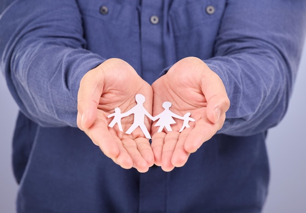 Handen tonen en man met papieren familie geïsoleerd op een paarse achtergrond in een studio Gemeenschapsverzekering en liefde voor een groep mensen samen en collectieve relaties in een palm op een achtergrond