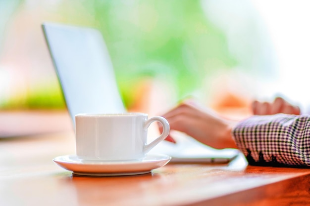 Handen typen op laptop in café