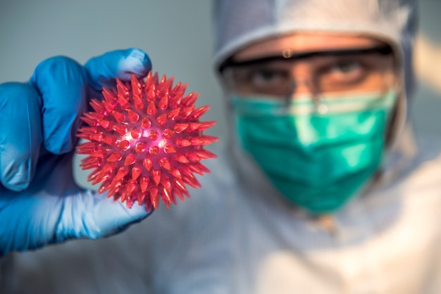 Foto handen van arts met corona-virusmodel