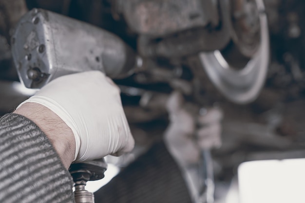 Handen van automonteur in autoreparatieservice.