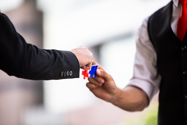 Handen van bedrijfsmensen houden samen document puzzel, Commerciële team het assembleren Figuurzaag