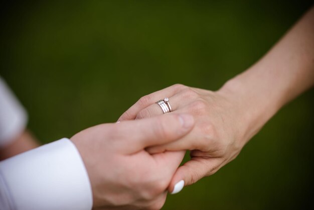 Handen van bruid en bruidegom met ringen bruid en bruidegom in een café bruiloft boeket tafel bruid en bruidegom houden elkaars handen vast Trouwringen Verliefde paar in een café hete thee voor geliefden