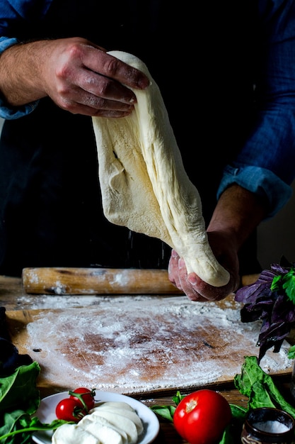 Handen van chef-kok Italiaanse chef-kok koken pizza man handen koken pizza deeg voor pizza koks handen