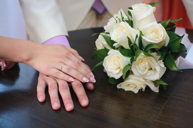 Handen van de bruid en bruidegom met gouden ringen op de bruiloft