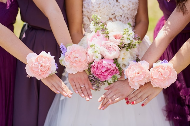 Handen van de bruid en vriendin met decoratieve bloemen