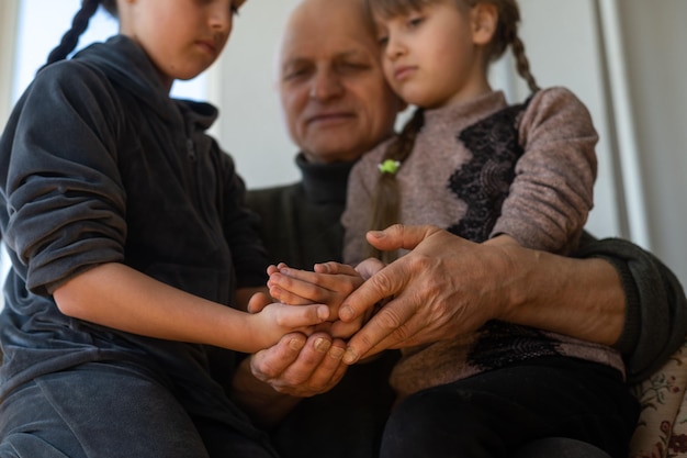 Handen van de oude man en de hand van een kind.