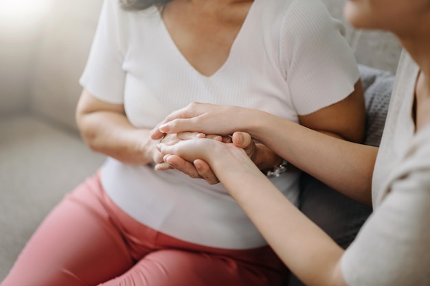 Handen van de oude vrouw en een vrouw dienen huis in