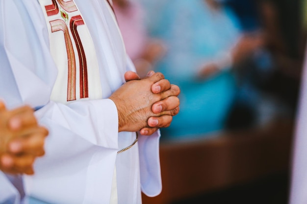 Handen van de priester tijdens de viering van de Heilige Communie