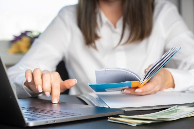 Handen van een financiële werker in een wit overhemd die met documentenclose-up werkt.