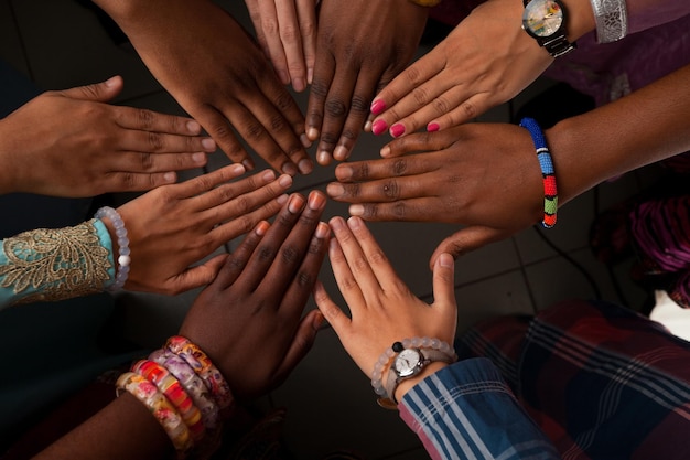 Handen van een gelukkige groep Afrikaanse mensen die bij elkaar blijven in een gelukkige cirkel