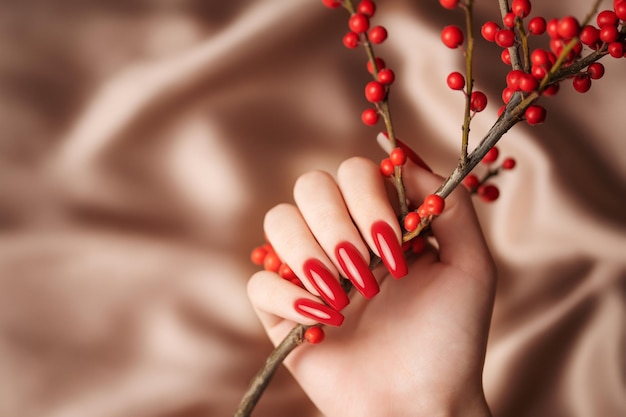 Handen van een jong meisje met rode manicure op nagels