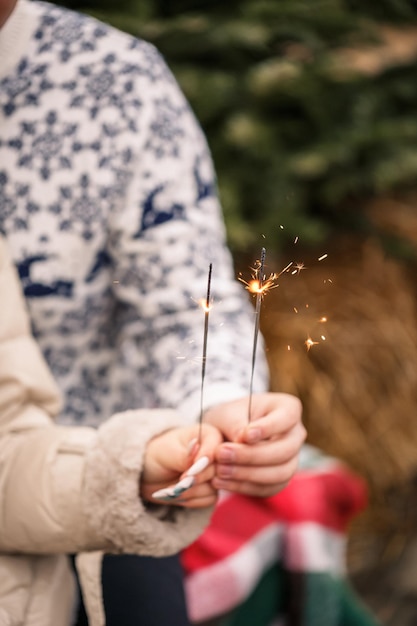 Handen van een man en een vrouw close-up met een brandend sterretje feestelijke lichten