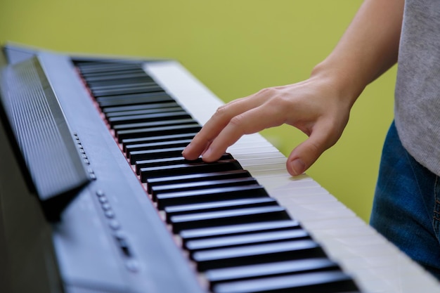 Handen van een meisje dat elektronische piano speelt Het meisje dat synthesizer speelt