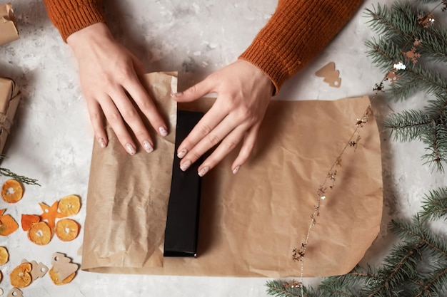 handen van een meisje dat geschenken inpakt voor het nieuwe jaar en geschenken geeft voor het nieuwe jaar