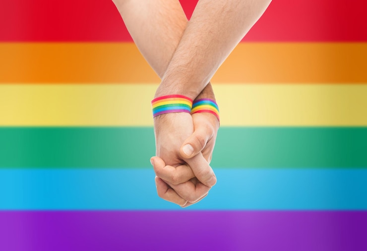 Foto handen van een stel met gay pride regenboog armbanden