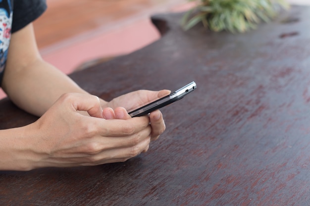 Handen van een vrouw die een mobiele celtelefoon met behulp van