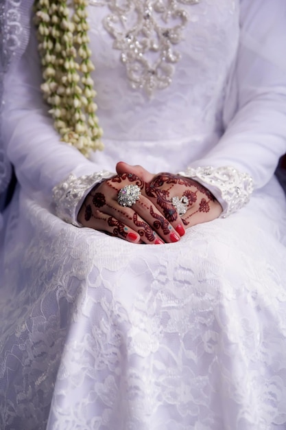 Foto handen van een vrouw die henna draagt tijdens een huwelijksstoet.