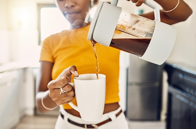 Handen van een vrouw die koffie in een mok giet die in een keuken thuis staat Franse pers met zelfgemaakte verse en heerlijke warme drank om de ochtend of dag te beginnen met een gebrouwen cafeïnedrank