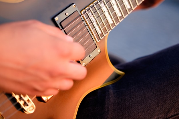 Foto handen van gitarist die elektrische gitaarakkoorden spelen