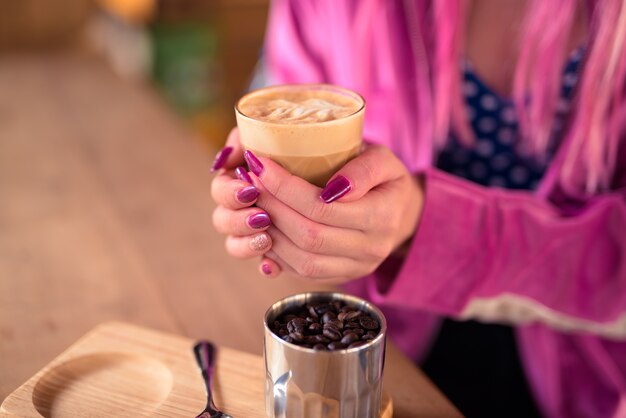 Handen van jonge vrouw koffie drinken en ontspannen in de coffeeshop