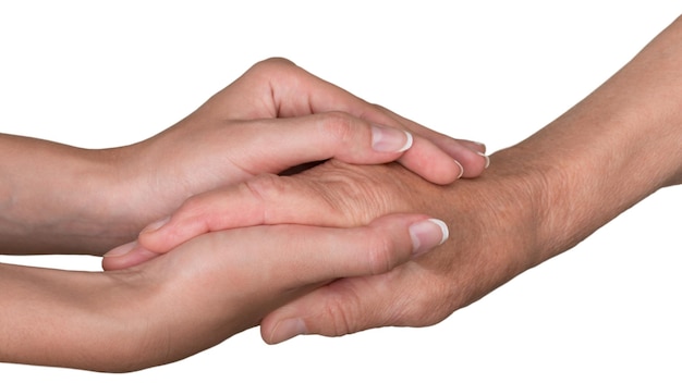 Foto handen van jonge vrouwen die de hand van een oude vrouw aanraken en vasthouden