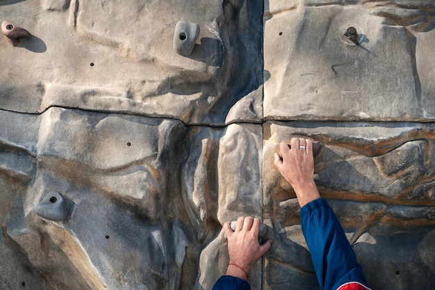 Handen van mannelijke klimmer training op klimmuur