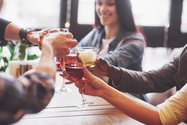 Handen van mensen met glazen whisky of wijn, vieren en roosteren