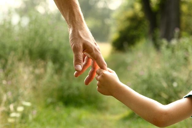 Handen van ouder en kind in de natuur