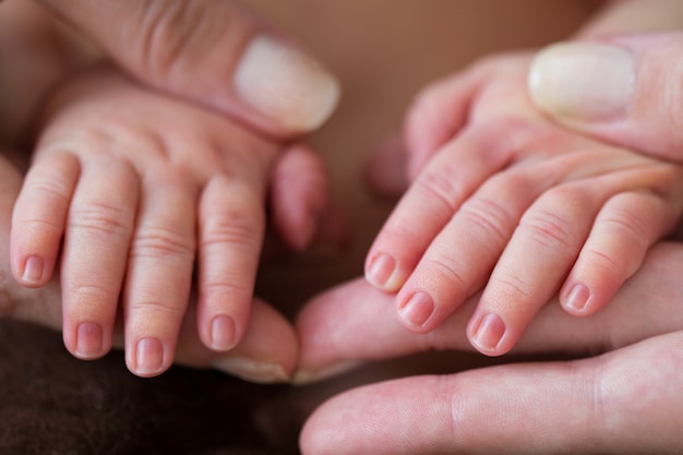 handen van pasgeboren moeder en baby