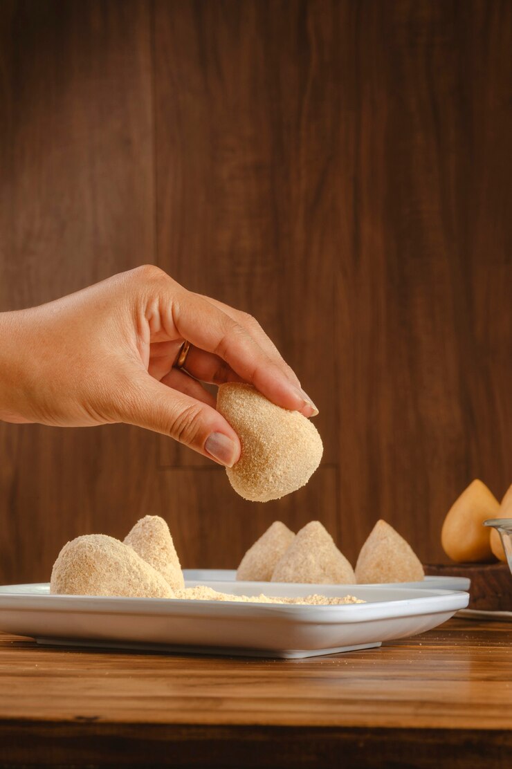 Handen van vrouw die Braziliaanse kroket paneren