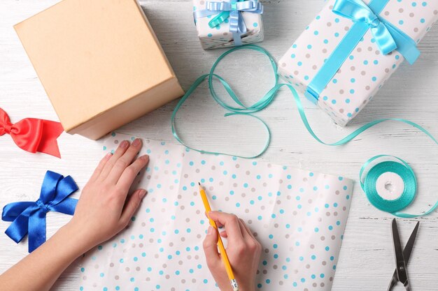 Handen van vrouw die cadeautjes inpakt voor vakantie