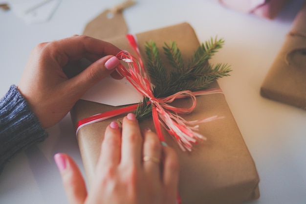 Handen van vrouw die de doos van de gift van Kerstmis verfraaien Handen van vrouw Kerstmis