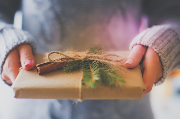 Handen van vrouw met kerstcadeaudoos Kerstmis