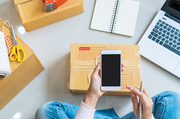 Handen van vrouw ondernemer met smartphone. business, technologie concept. bovenaanzicht, kopieer ruimte