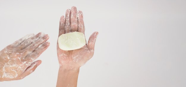 Handen wassen gebaar met zeep en schuim zeepbel op witte achtergrond.